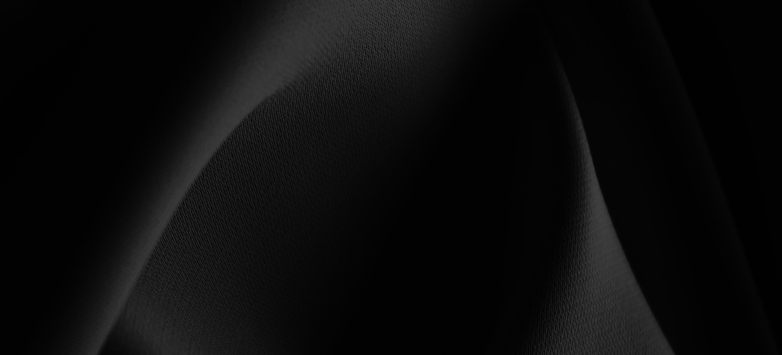 Textured black fabric in soft, flowing drapes.