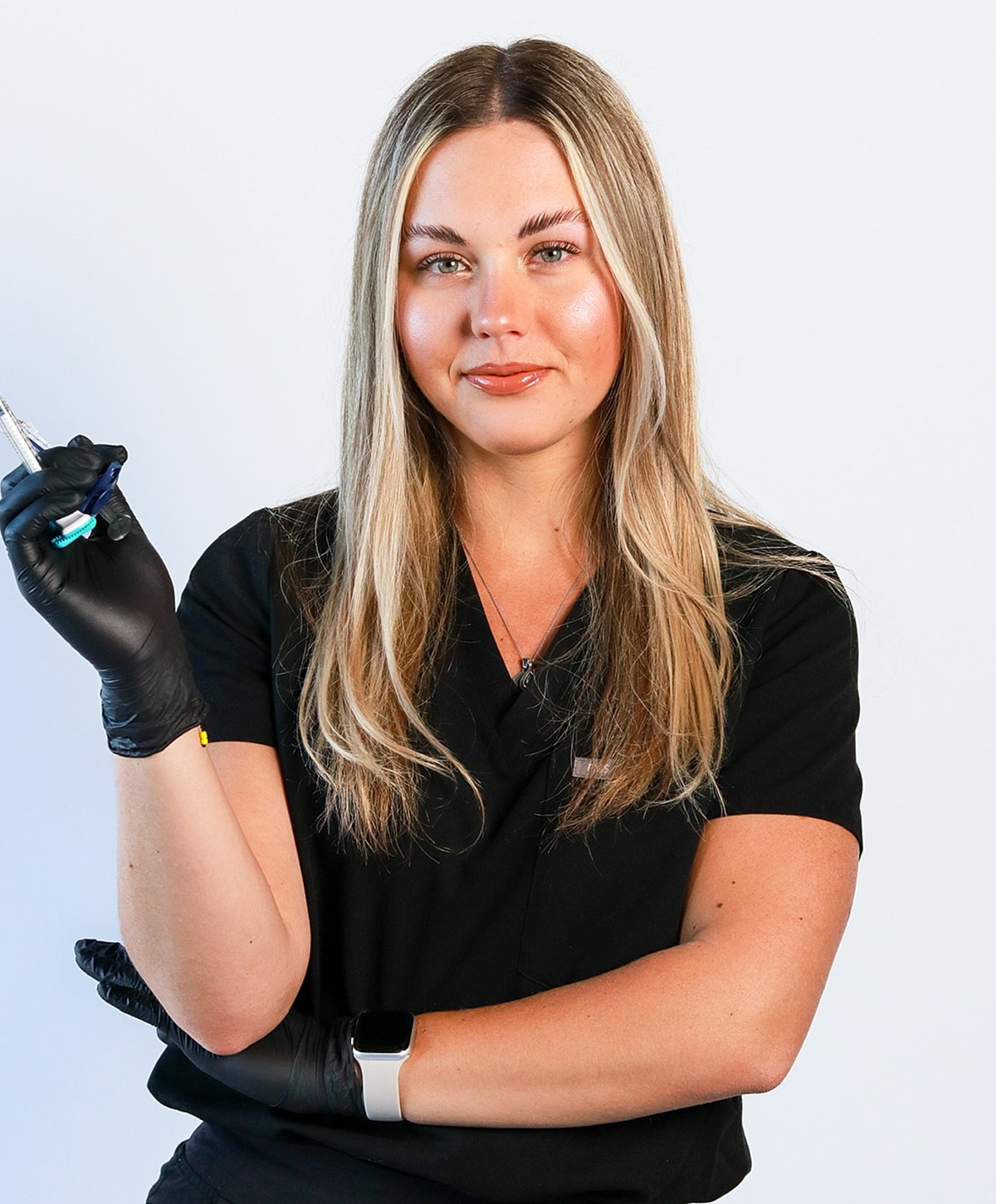 Health professional holding a syringe and smiling.
