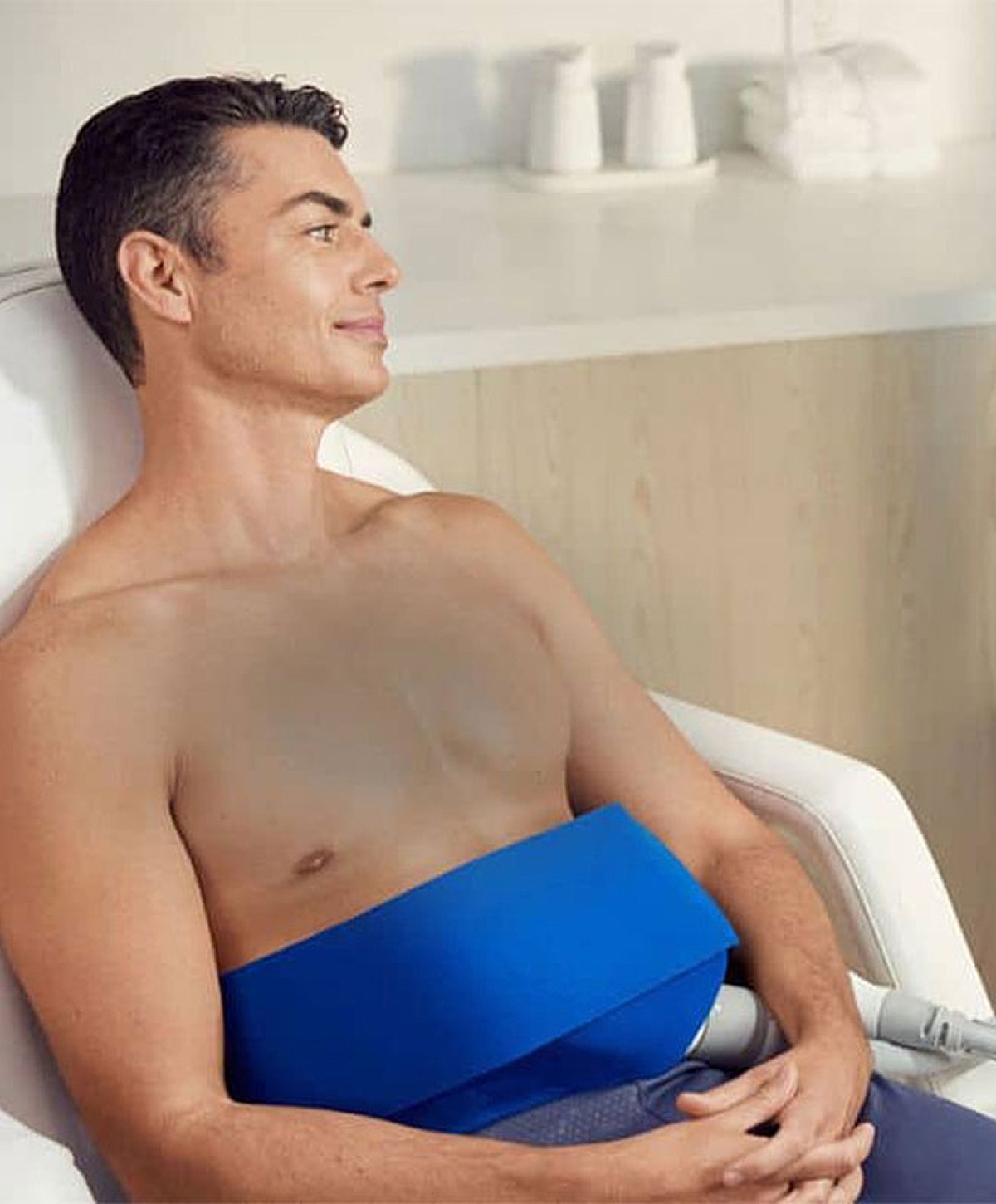 Man in spa treatment, relaxed expression, blue wrap.