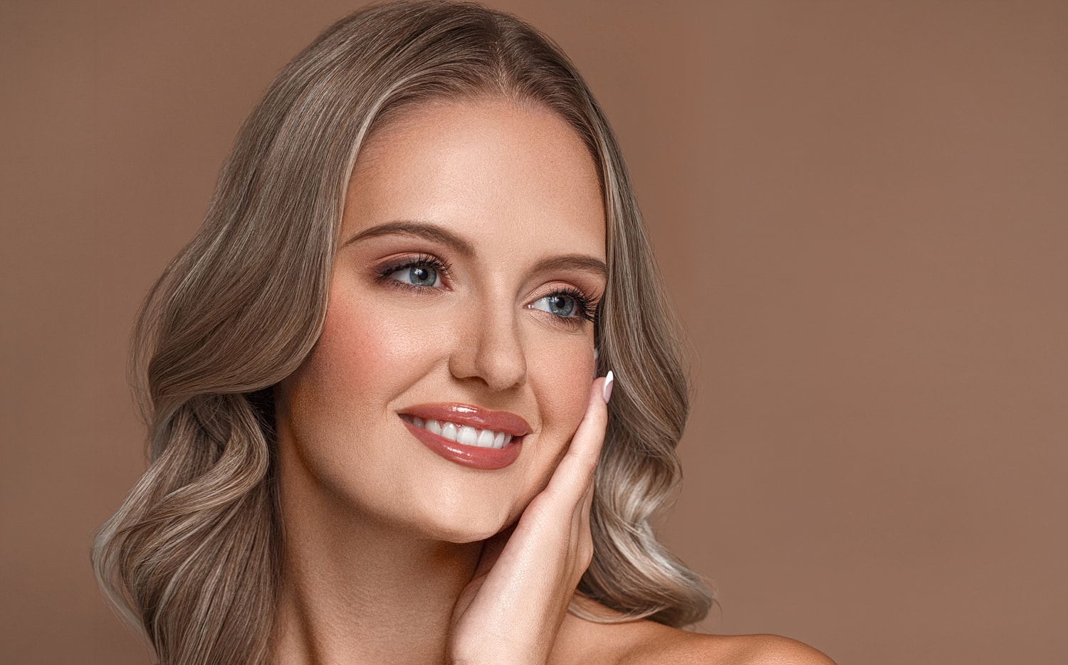 Smiling woman with blonde hair and neutral background