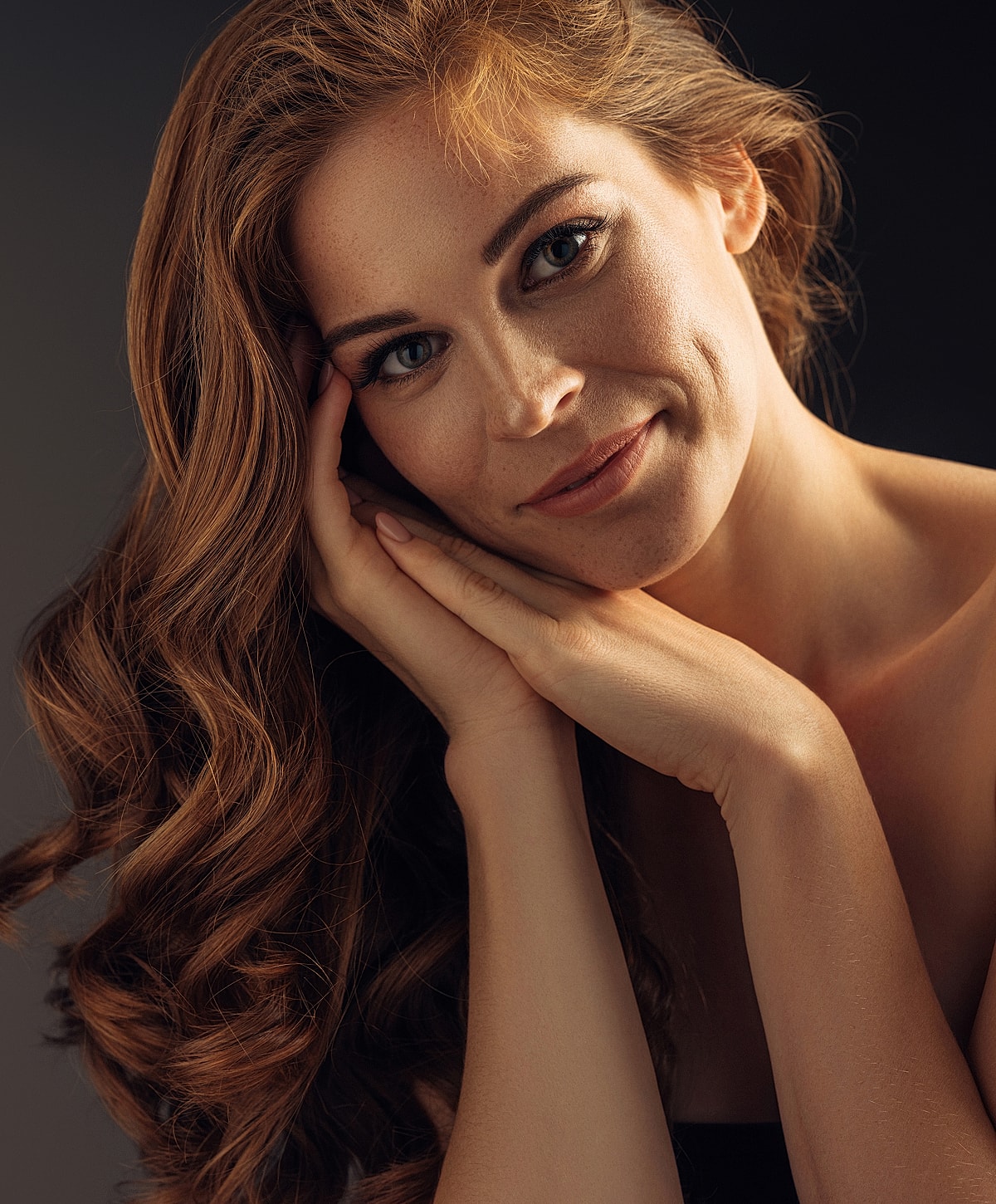 Smiling woman with long, wavy hair.