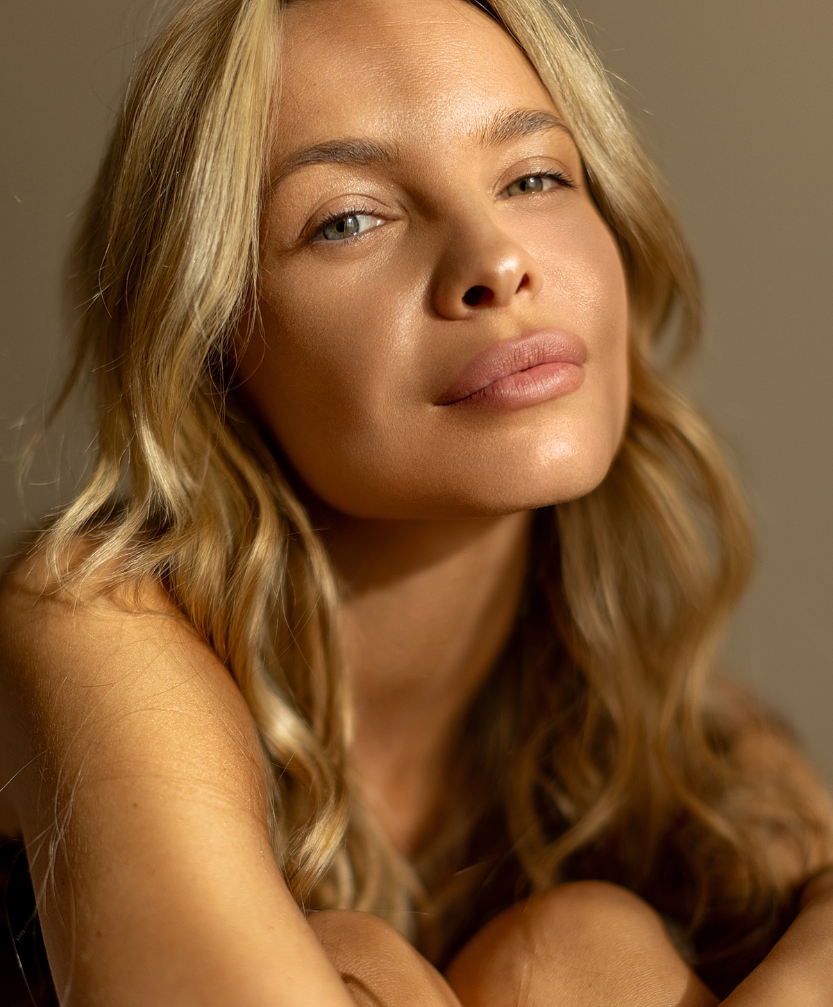 Blonde woman with natural makeup and soft expression.