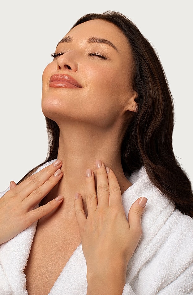 Woman in robe enjoying a skincare moment.