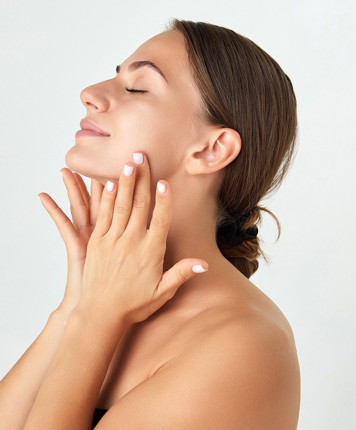 Woman gently touching her face, serene expression.