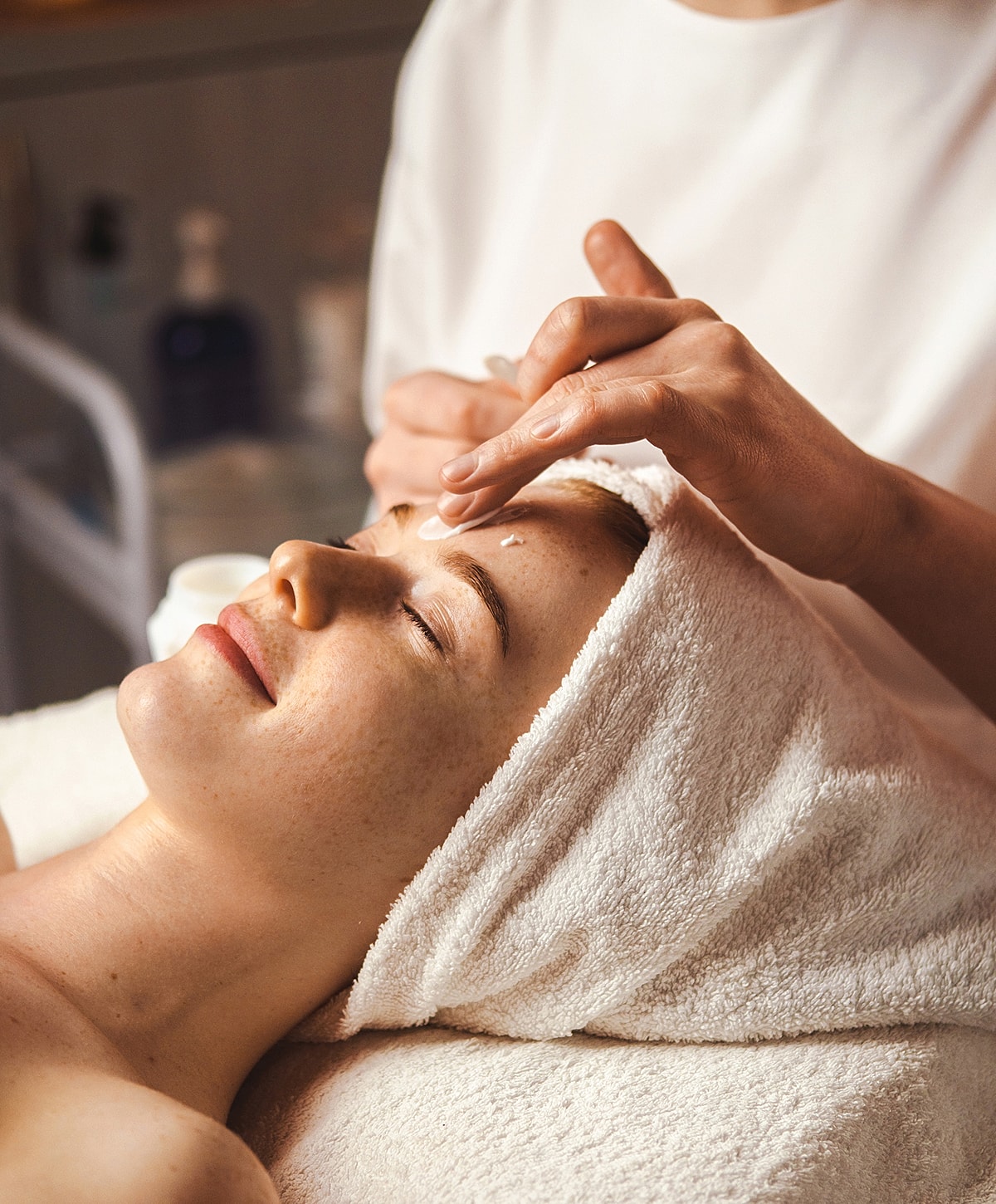 Woman receiving a facial treatment in spa.